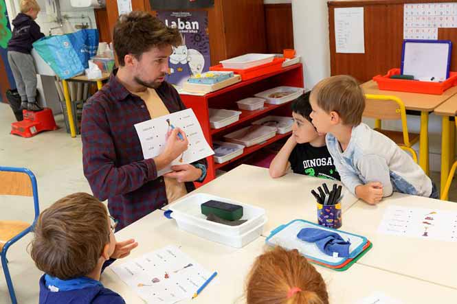 Un professeur montre des mots à des élèves de primaire