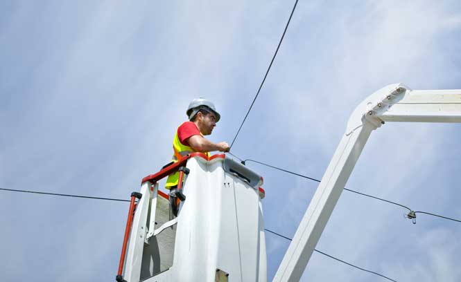 Un technicien dans une nacelle travaille sur une ligne
