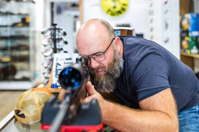 Un armurier réalise le réglage d'un fusil à lunette