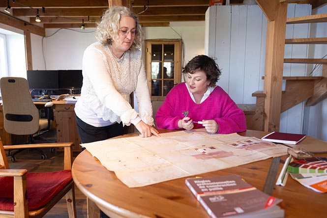 Leila Henry et Charlotte Duhot travaillent sur le plan d'un bâtiment.
