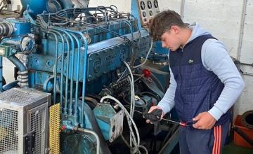 Un élève regarde le niveau d&#039;huile dans un moteur de bateau