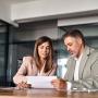 Deux personnes discutent à un bureau.