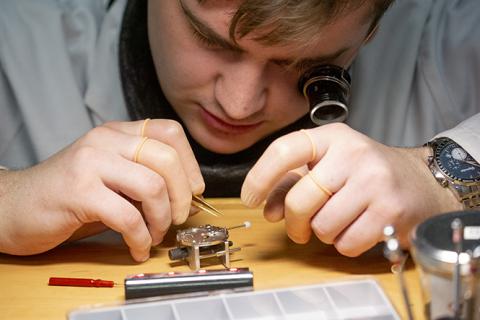 Horloger qui manipule des pièces