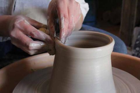 Mains qui travaillent sur un vase en céramique