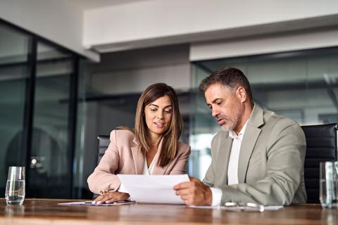 Deux personnes discutent à un bureau.