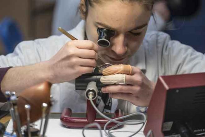 Jeune fille réparant une montre