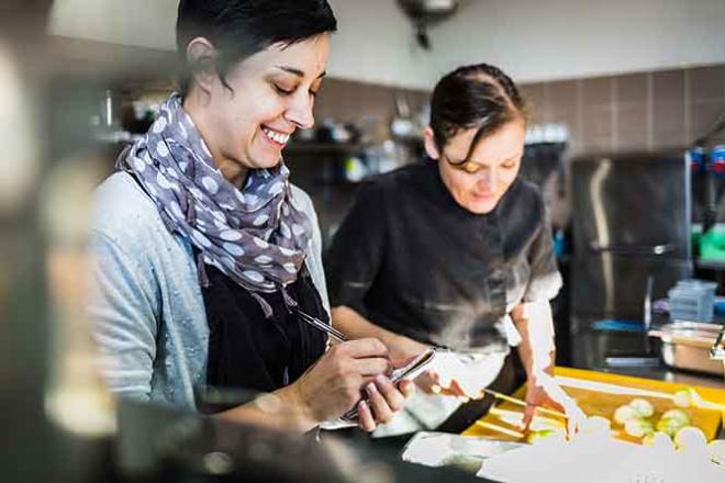 La cheffe de cuisine reçoit les commandes de la salle. La cheffe de cuisine reçoit les commandes de la salle.