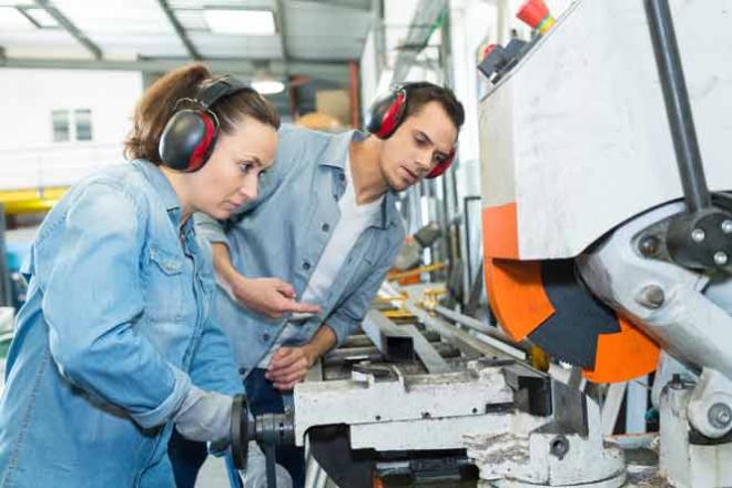 Acquérir de nouvelles compétences tout au long de sa vie professionnelle Jeune femme qui apprend à se servir d'une machine
