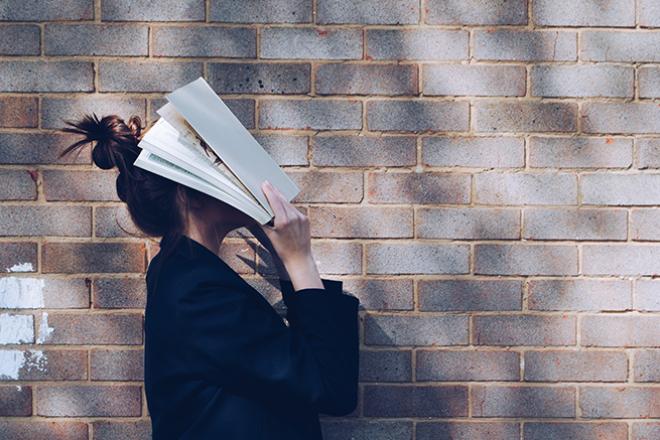 Rechercher des offres de stage Une personne se couvre le visage avec un livre