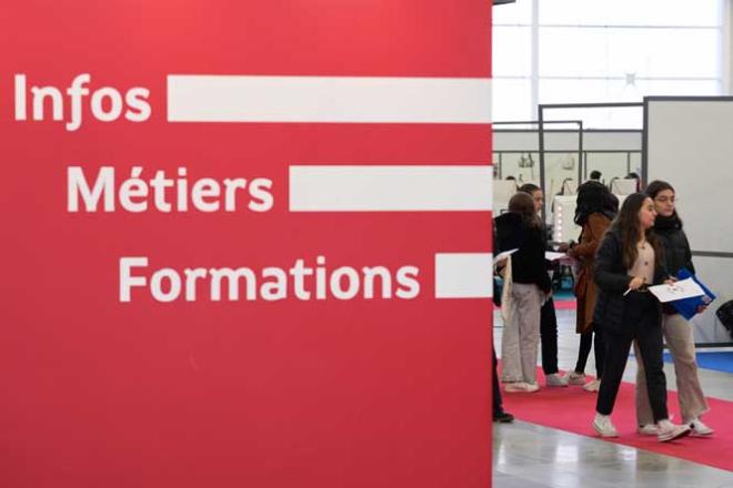 Vue d&#039;un salon d&#039;orientation avec un panneau indiquant &quot;Infos métiers formations&quot;