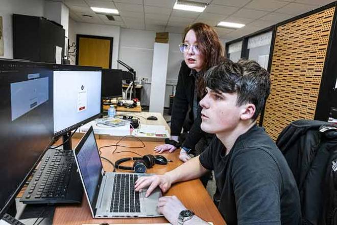 Un apprenti devant un ordinateur à côté de sa maîtressed'apprentissage