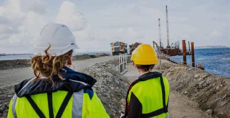 Deux professionnelles sur un chantier regardent des engins